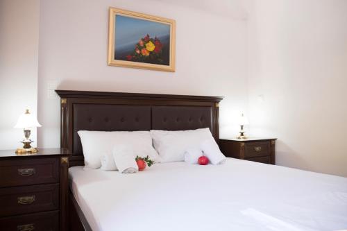 Un dormitorio con una cama blanca con dos manzanas. en Vrachos Solymar, en Paralia Vrachou