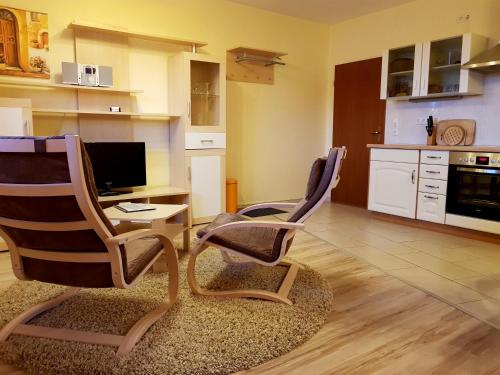 a living room with two chairs and a desk with a computer at Flensburg Ferienwohnungen Apartment 2 in Flensburg