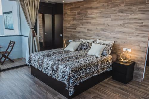 プラヤ・ハンディアにあるLoft del Mar 2 Jandiaの木製の壁のベッドルーム1室(ベッド1台付)