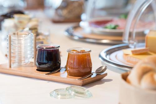 a table topped with jars of jam and spoons at Pension Löwen in Andelsbuch