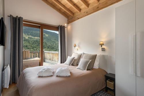 a bedroom with a large bed with a large window at Chalet Zebra in Méribel
