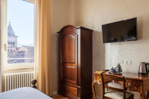 a bedroom with a wooden cabinet and a desk with a television at Regina Bed and Breakfast in Tivoli
