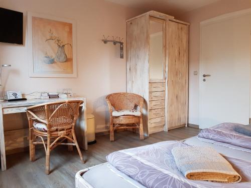 Schlafzimmer mit einem Bett, einem Schreibtisch und Stühlen in der Unterkunft Gästehaus Flensburg Engelsby in Flensburg