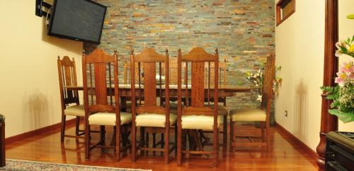 a dining room table with chairs and a television at Hospedaje klickmann in Temuco