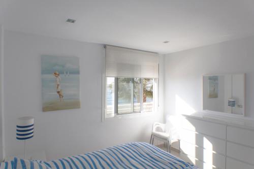 リンコン・デ・ラ・ビクトリアにあるApartamento Mediterráneoの白いベッドルーム(ベッド1台、窓付)