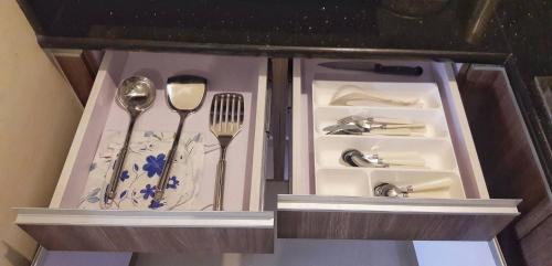 a wooden cabinet with utensils in it at Azalea Place Robinsons Residences Cebu in Cebu City