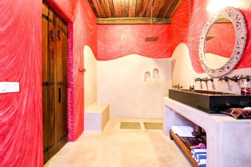 a bathroom with red curtains and a mirror at IKSHAA Luxury Villa with Private Pool in Majorda