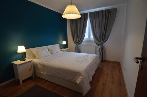 ein Schlafzimmer mit einem Bett und einer blauen Wand in der Unterkunft AVA Apartments ADORA FOREST 1 in Timişoara