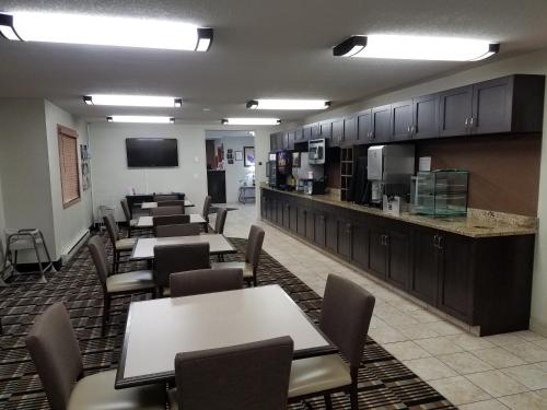 a cafeteria with tables and chairs and a kitchen at Americas Best Value Inn and Suites Bismarck in Bismarck
