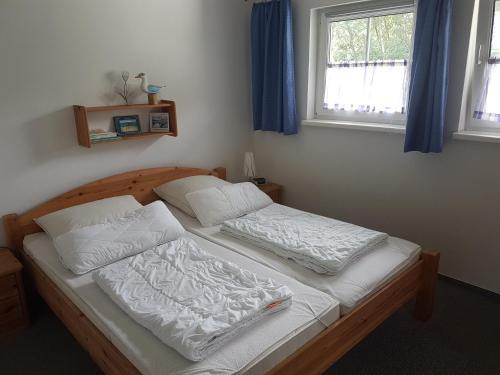 a bed in a bedroom with two white pillows at Ferienhaus Zinnowitz in Zinnowitz