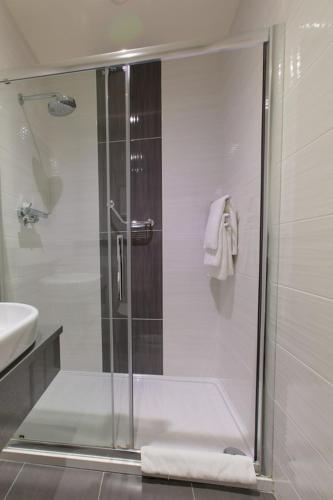 a shower with a glass door in a bathroom at Grand Hotel Tralee in Tralee