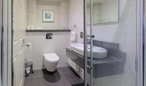 a white bathroom with a sink and a toilet at Grand Hotel Tralee in Tralee