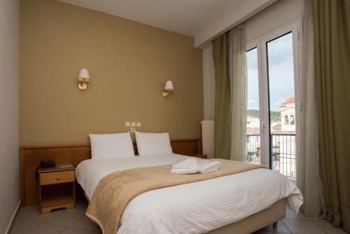 a bedroom with a bed and a large window at Morfeas Hotel in Argos