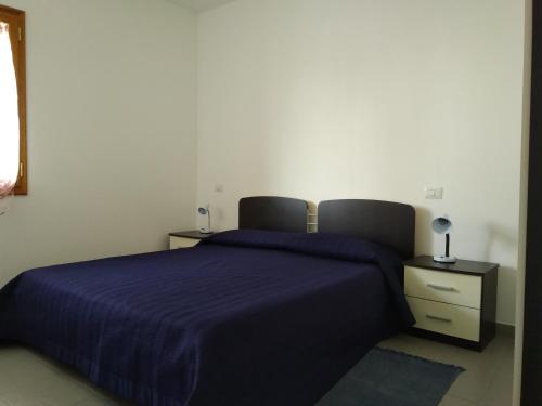 トルトリにあるAppartamenti Demurtasのベッドルーム1室(大型ベッド1台、青い毛布付)