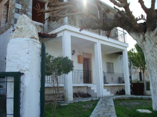 a white house with a balcony on top of it at Thanasis Efh House in Stenón