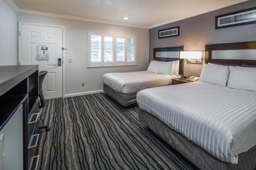 um quarto de hotel com duas camas e uma cozinha em Redwood Creek Inn em Redwood City