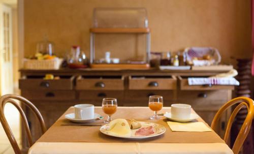 Saint-PalaisにあるHôtel-Restaurant de La Paixのワイングラス2つと食べ物が置かれたテーブル