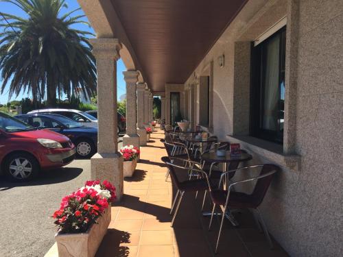 a row of tables and chairs on the side of a building at Hotel Florida in A Lanzada