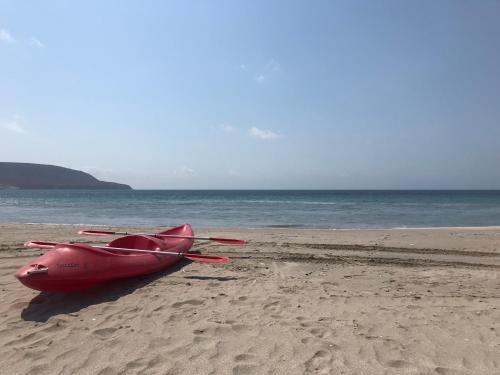 a red boat sitting on the sand on the beach at Condominio Bahia Inglesa in Bahia Inglesa