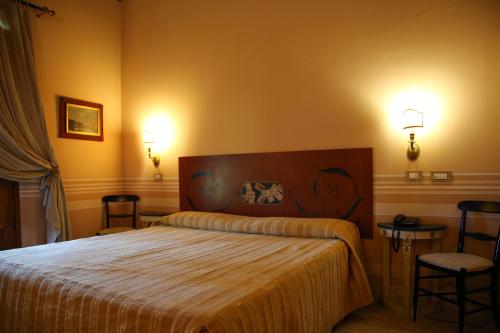 a bedroom with a bed and two lights on the wall at Il Piccolo Castello in Monteriggioni