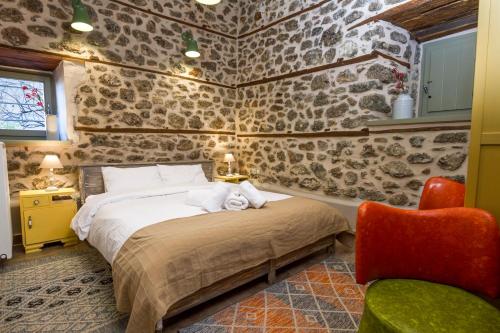 a bedroom with a bed in a room with stone walls at Bayiri Petit Pension in Litochoro