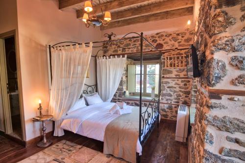 a bedroom with a bed and a stone wall at Bayiri Petit Pension in Litochoro