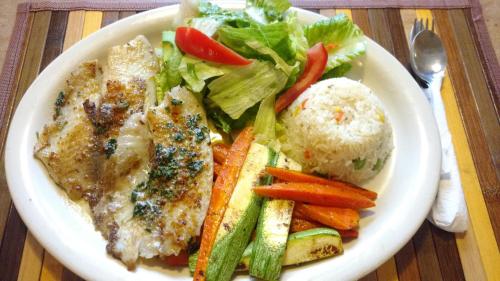 a plate of food with rice and vegetables on a table at Hotel Azteca de Oro Mexicali in Mexicali