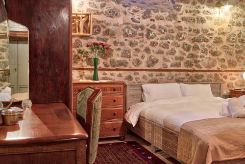 a bedroom with a bed and a dresser and a desk at Bayiri Petit Pension in Litochoro