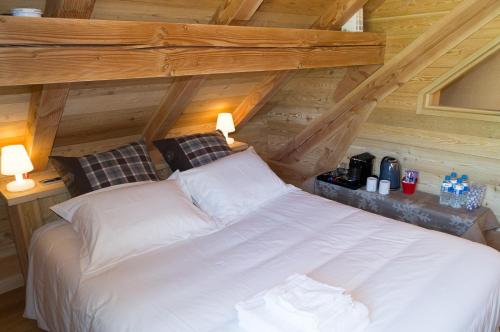 a large white bed in a room with wooden ceilings at Chambres d'hôtes La Vercouline in Villard-de-Lans