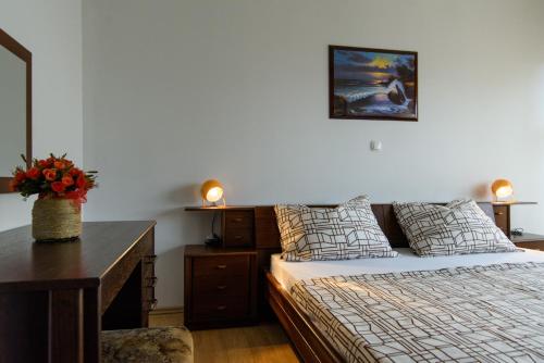Un dormitorio con una cama y un escritorio con flores. en Apartments Sofija, en Trogir