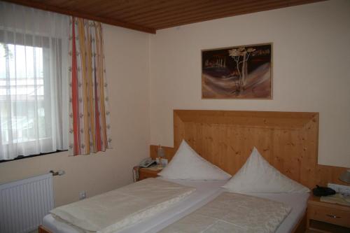 a bedroom with a bed and a window at Wellness Pension Hollaus in Kirchberg in Tirol