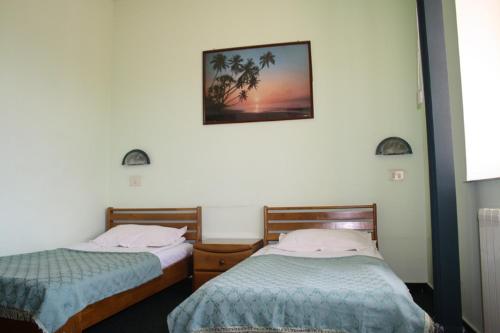 1 dormitorio con 2 camas y una foto en la pared en Hotel Paradis, en Slatina