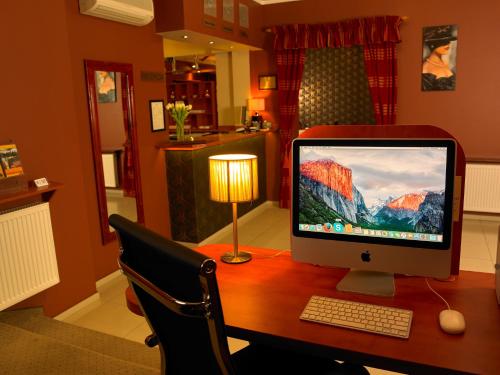 a computer monitor sitting on a desk with a chair at Aura - Hotel & Restaurant & Sauna in Zielona Góra