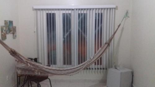 a hammock in front of a window in a room at Expedito acomodações in Manaus