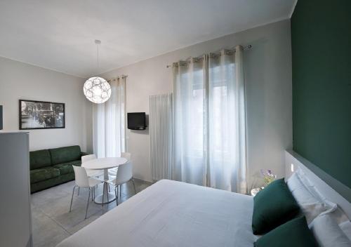 a bedroom with a bed and a couch and a table at Bacio di Dama Lingotto in Turin