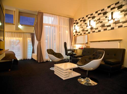 a living room with a couch and chairs and a table at Aura - Hotel & Restaurant & Sauna in Zielona Góra