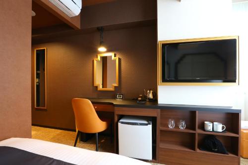 a hotel room with a desk and a tv at Hotel Wing International Select Osaka Umeda in Osaka
