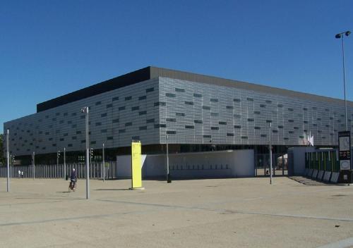a large building with a person walking in front of it at Bacio di Dama Lingotto in Turin