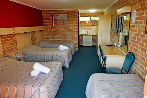 Kleines Zimmer mit 3 Betten und einer Küche in der Unterkunft Windsor Terrace Motel in Windsor