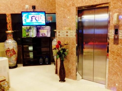 a lobby with a vase with a flower in it at Penang Palace in Bangkok
