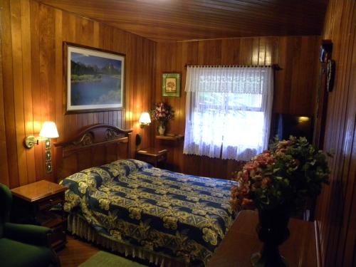 Schlafzimmer mit einem Bett und einem Fenster in der Unterkunft Hotel Akaskay in Nova Friburgo