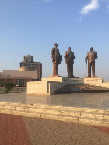 three statues of three people standing in front of a monument at Urban Awe Apartment-iTowers 23rd Floor in Gaborone