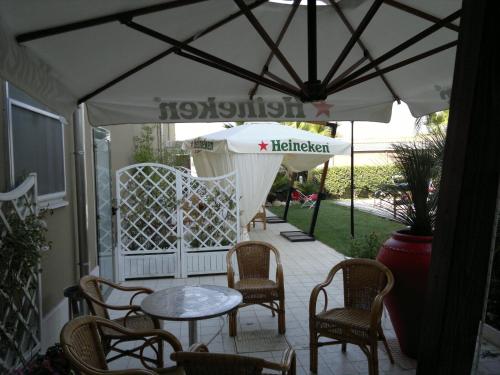 un patio con mesa, sillas y sombrilla en Hotel Novelli, en Orta Nova