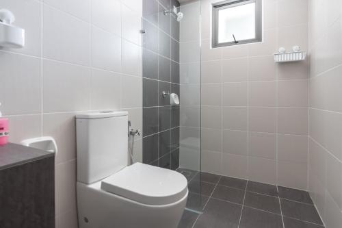 a white bathroom with a toilet and a shower at Comfort Zone Premium Guesthouse @ Evo Bangi in Bangi