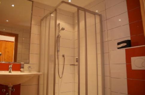 ein Bad mit einer Dusche und einem Waschbecken in der Unterkunft Hotel Stolz in Matrei am Brenner