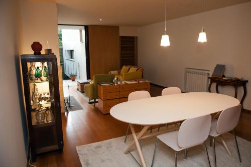 uma sala de estar com uma mesa branca e cadeiras em Civitá Design & Accommodation em Braga