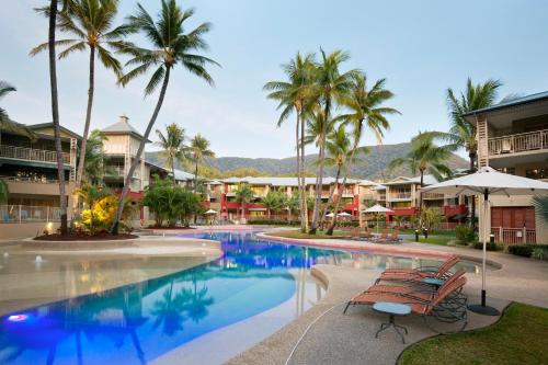 a pool at a resort with palm trees at Mantra Amphora in Palm Cove