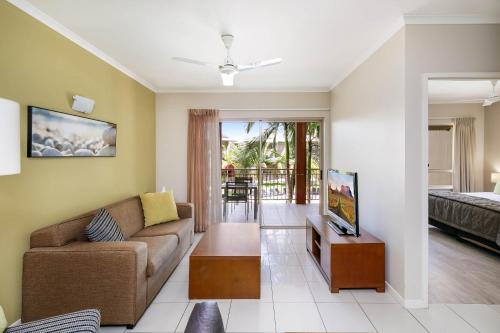 a living room with a couch and a table at Mantra Amphora in Palm Cove