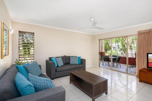 a living room with a couch and a table at Mantra Amphora in Palm Cove