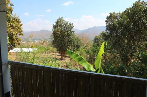a balcony with a view of trees and mountains at Pai Yard Guest House in Pai